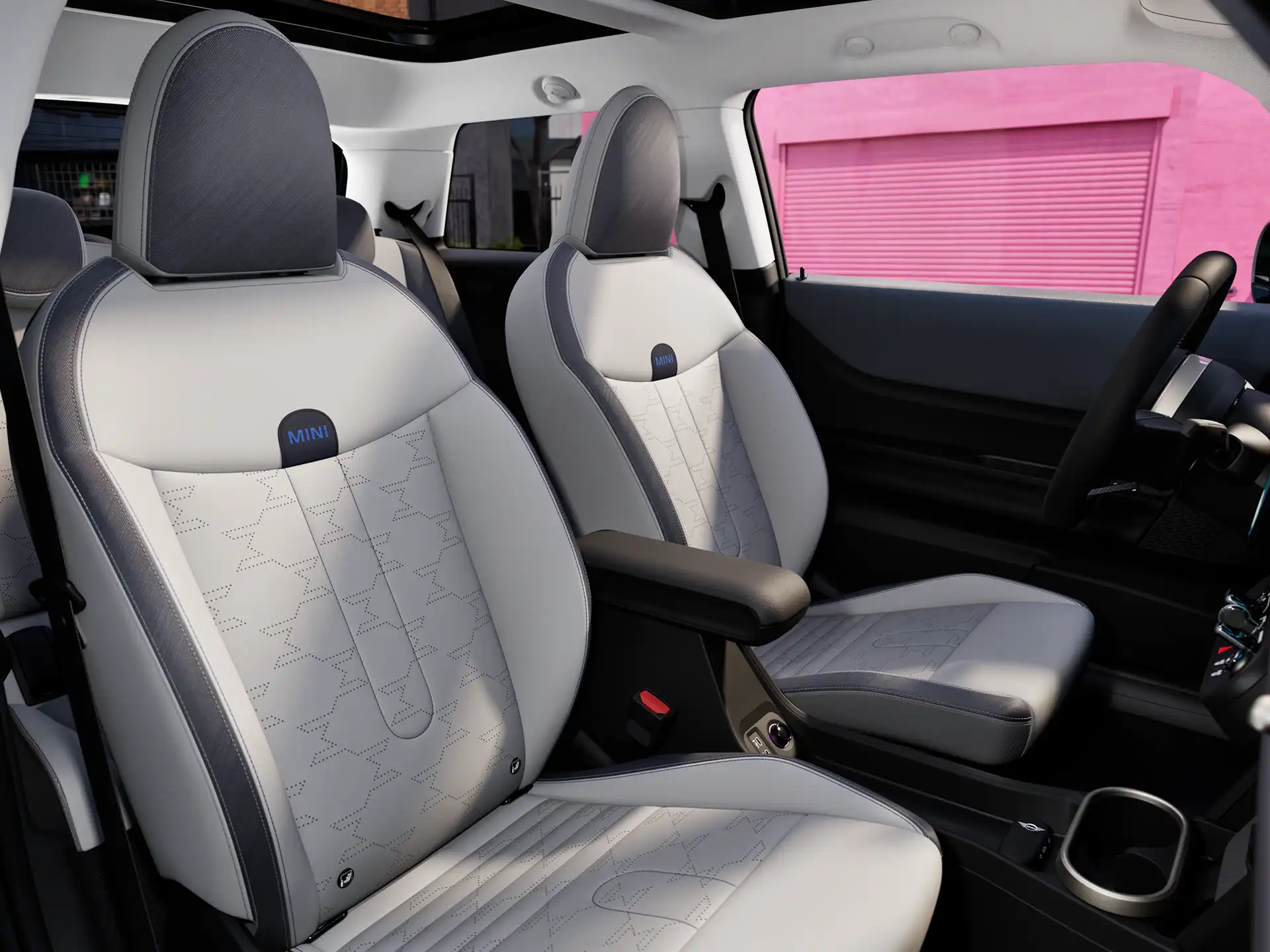 Invändig vy i MINI Cooper som visar instrumentpanel, ratt, rund display, panoramaglastak och ryggstödens baksida.