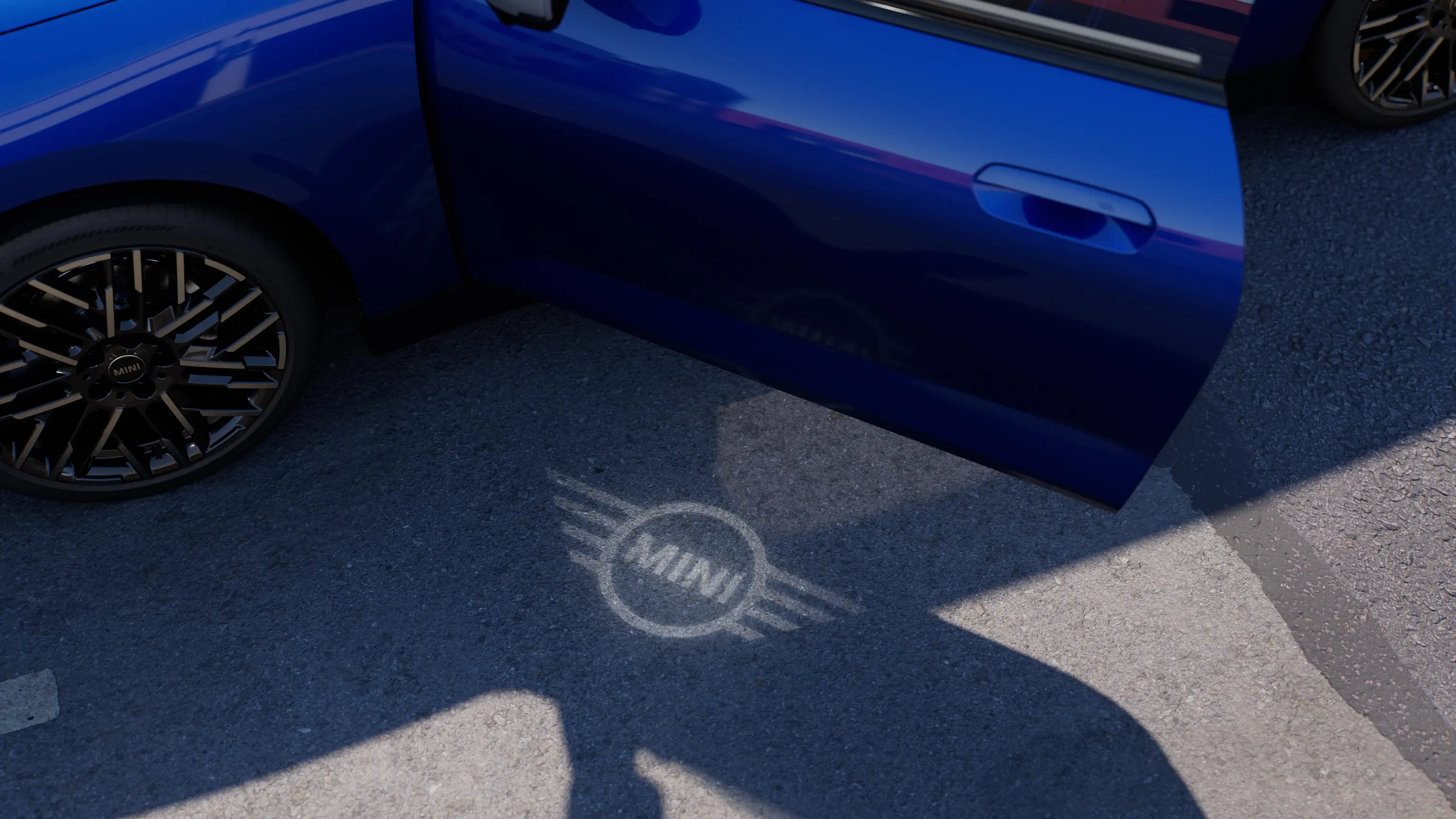 Exteriörbild på helt elektriska MINI Cooper med öppen dörr och välkomstljus i form av MINIs logotyp på marken