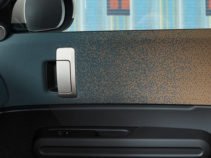 Närbild av inredningen i en helt elektrisk MINI Countryman med fokus på dörren och instrumentpanelen.