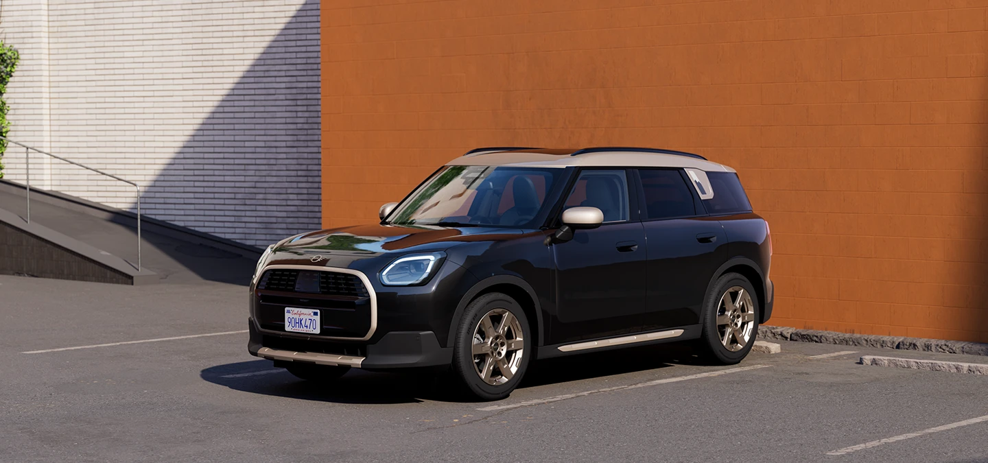 Vy framifrån av en MINI Countryman i Midnight Black och tak i Vibrant Silver som parkerar.