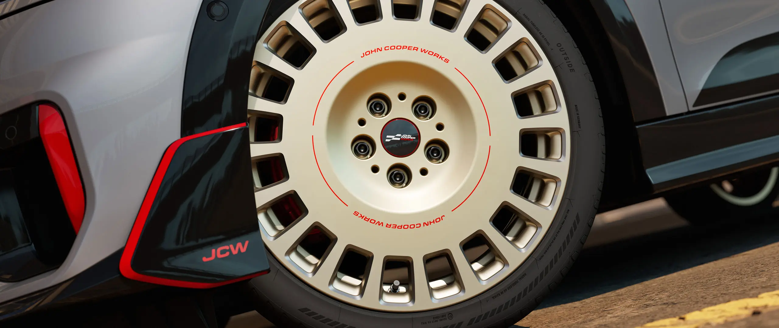 Närbild på detaljerna på ett 18" JCW Rallye Spoke-hjul 964 i tvåfärgad Vibrant Silver, diamantslipade och främre vinglet.