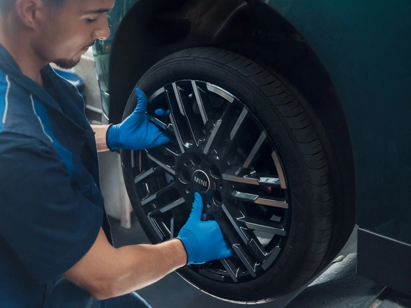 En MINI servicetekniker installerar en MINI 18" Night Flash Spoke tvåfärgad lättmetallfälg på en MINI Cooper Electric.
