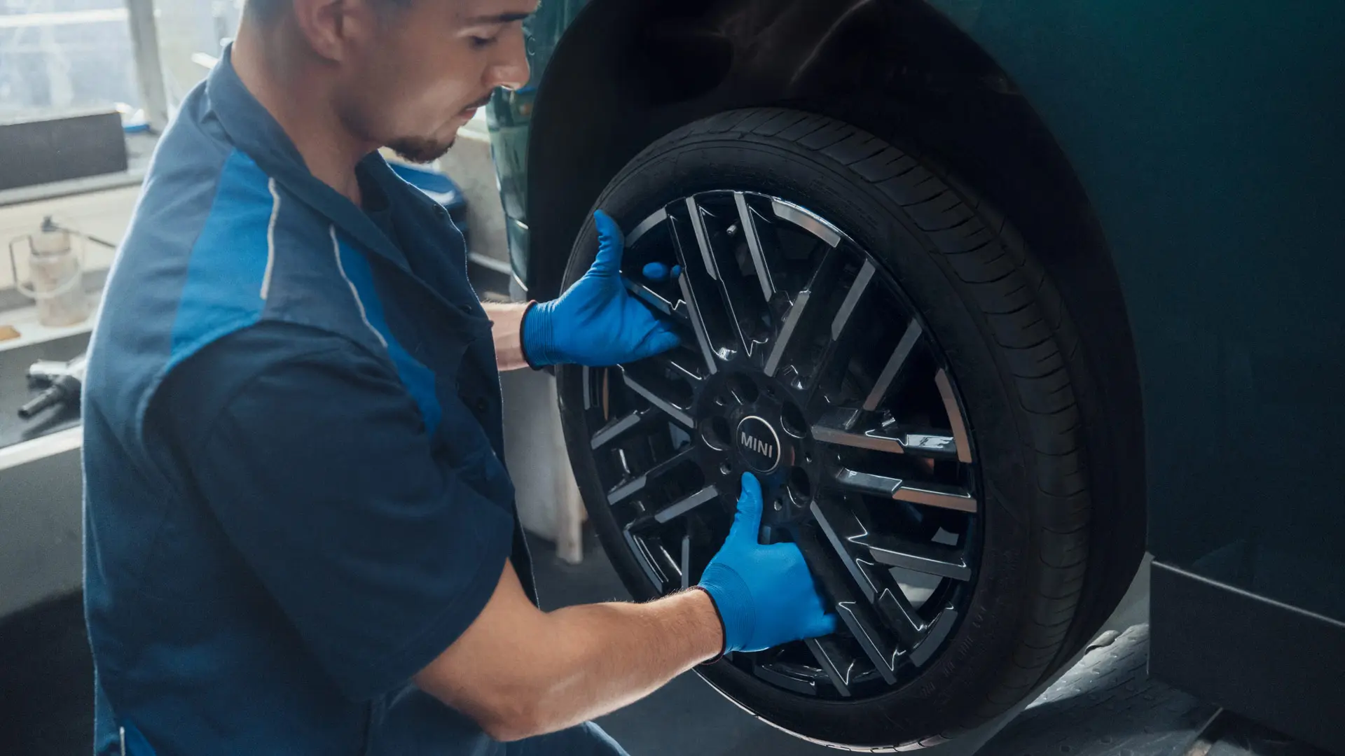 En MINI servicetekniker installerar en MINI 18" Night Flash Spoke tvåfärgad lättmetallfälg på en MINI Cooper Electric.