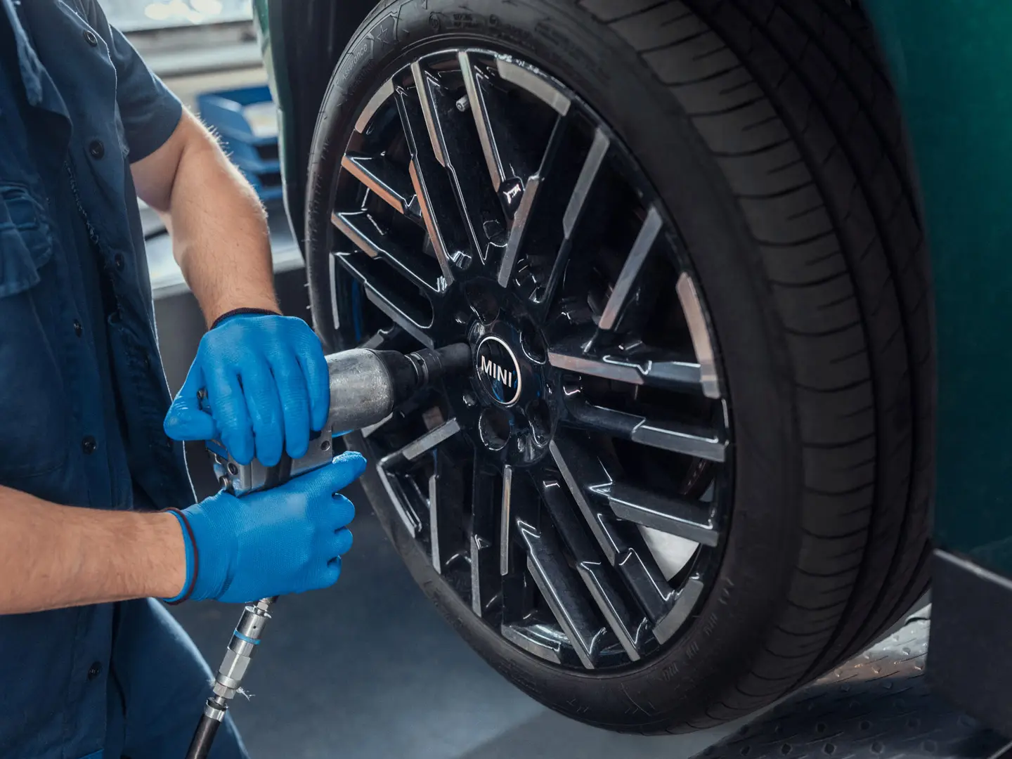 En servicetekniker från MINI Partner monterar en 18" Night Flash Spoke tvåfärgad lättmetallfälg på en MINI.