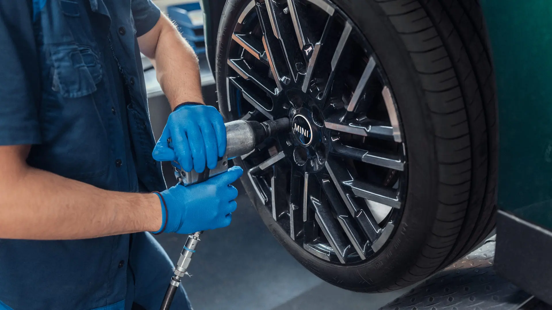 En servicetekniker från MINI Partner monterar en 18" Night Flash Spoke tvåfärgad lättmetallfälg på en MINI.