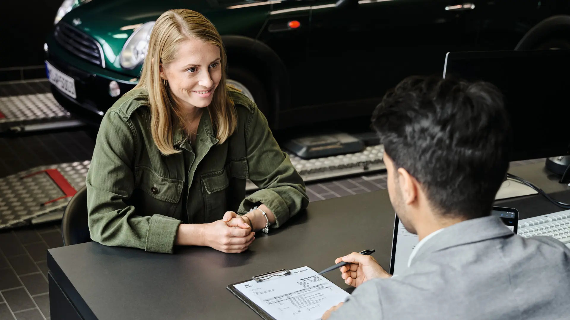 MINI center med expert som ger rådgivning till kund om servicealternativ, båda sitter vid ett bord.