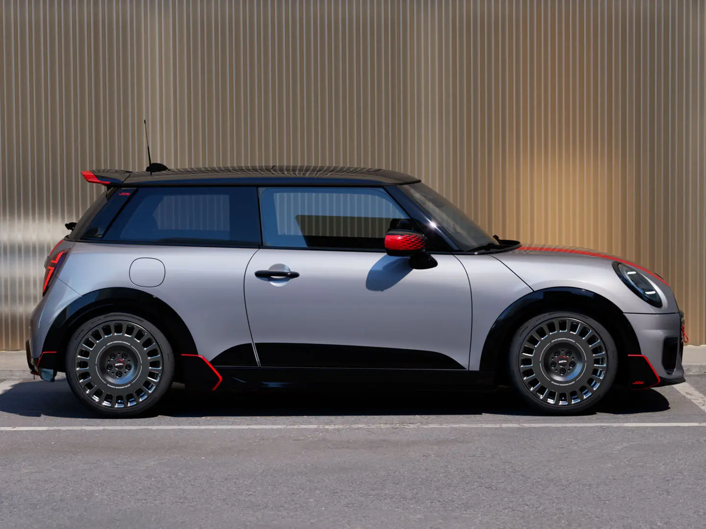 MINI Cooper 3-dörrars i Melting Silver med John Cooper Works takspoiler för bättre aerodynamiska egenskaper – sidovy.