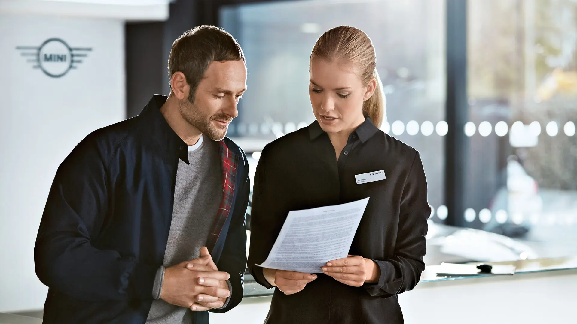 MINI servicerådgivare samråder med en kund om serviceplaner på ett MINI Center.