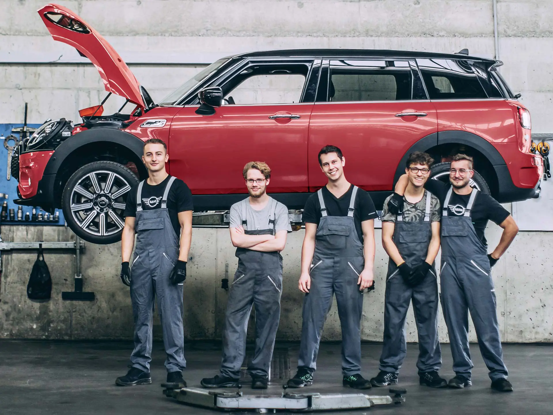 Serviceanställda hos MINI framför en MINI Countryman på en lift.