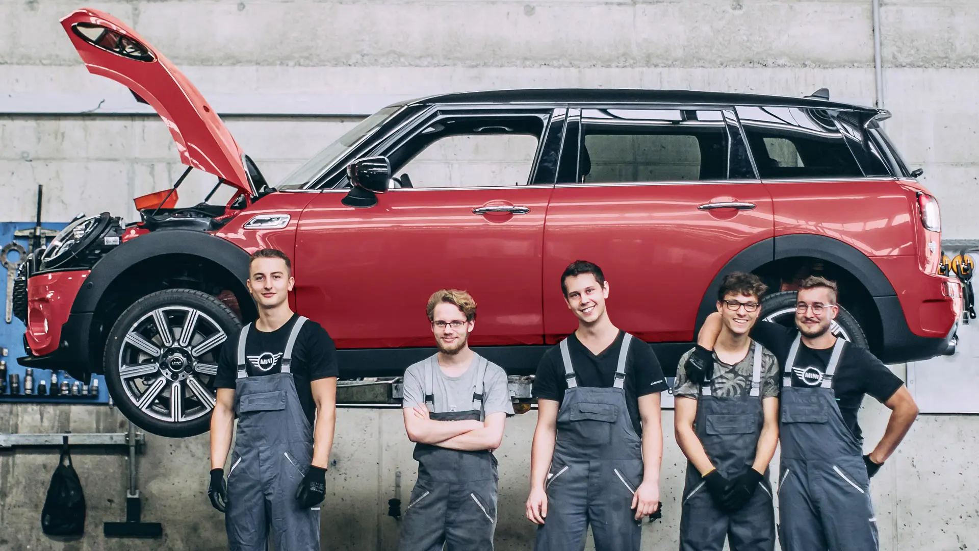 Serviceanställda hos MINI framför en MINI Countryman på en lift.