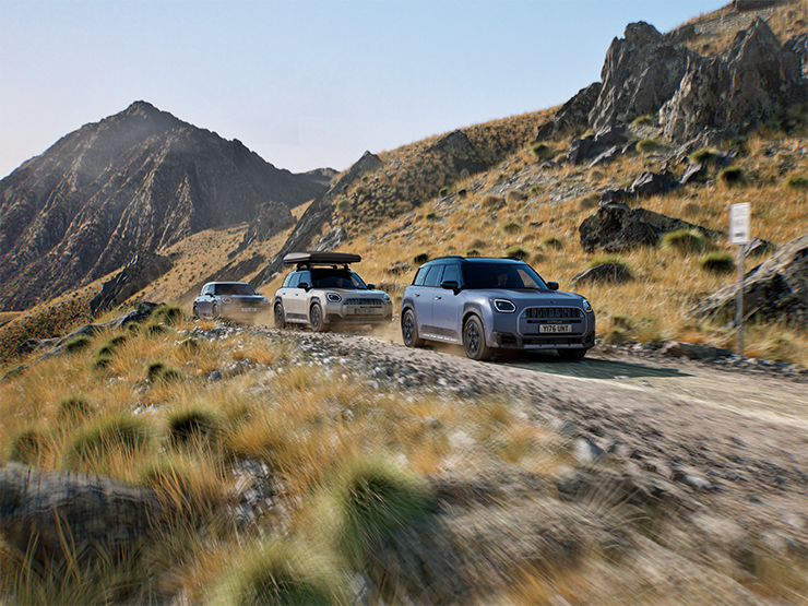 Bild på flera MINI Countryman Untamed Edition modeller som kör off-road på en bergsväg.