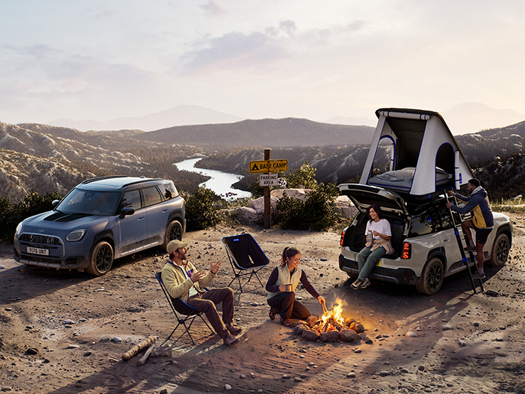 Bild på två MINI Countryman Untamed Edition fordon på ett berg i solnedgången.
