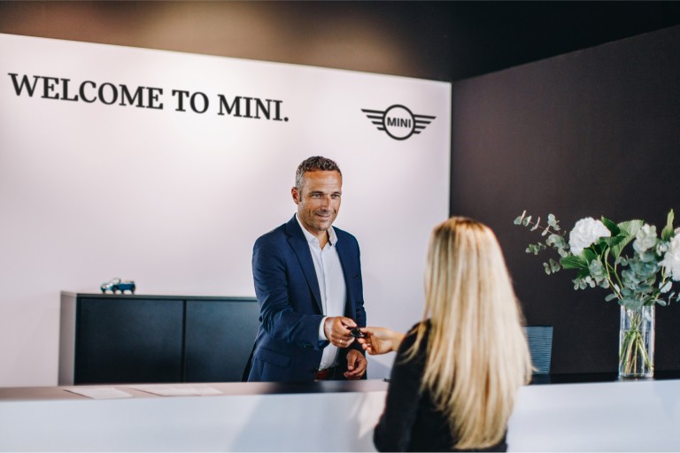 Receptionen hos en MINI Partner med anställd och kund